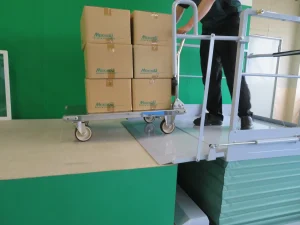 トラックから荷をおろす・積み込む、移動式段差解消用シザーリフト、段差らく～だ、渡り板により移動